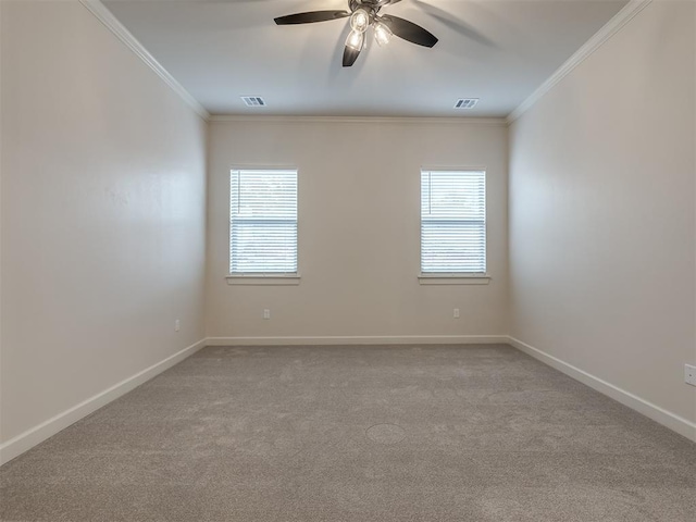 carpeted spare room with ceiling fan, a healthy amount of sunlight, and ornamental molding