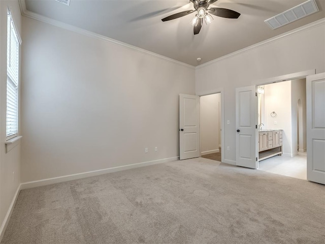 unfurnished bedroom with ensuite bathroom, light carpet, ornamental molding, ceiling fan, and a barn door