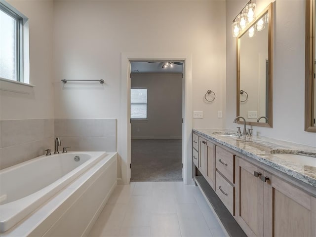 bathroom with vanity, a tub, and tile patterned floors