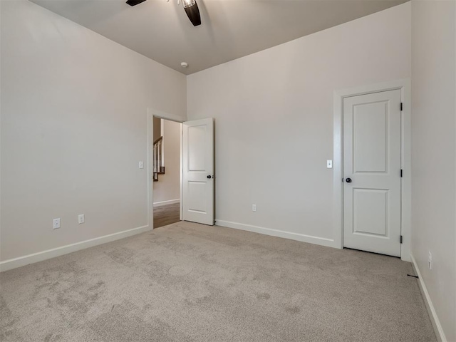 unfurnished bedroom featuring light colored carpet and ceiling fan