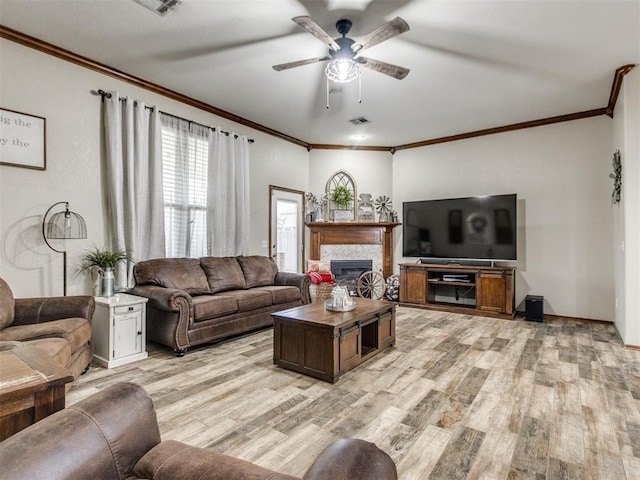 living room with crown molding, ceiling fan, and light wood-type flooring