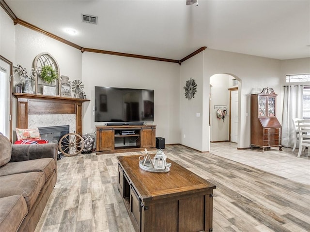 living room featuring crown molding and light hardwood / wood-style floors