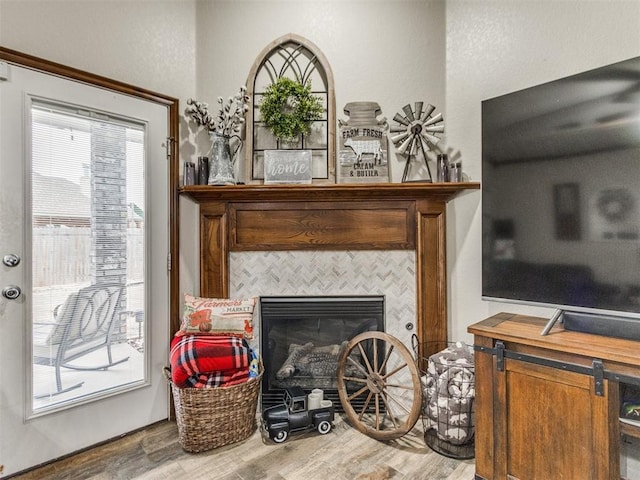 interior details with a tiled fireplace and wood-type flooring