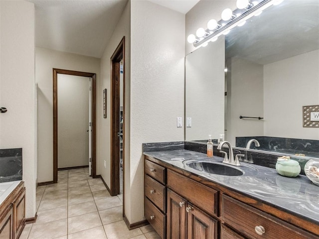 bathroom with tile patterned floors, a bathtub, and vanity