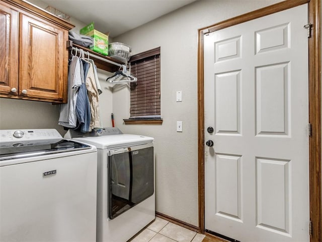 laundry room featuring cabinets, washing machine and dryer, and light tile patterned floors