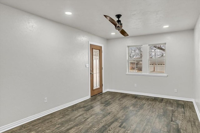 empty room with ceiling fan and dark hardwood / wood-style flooring