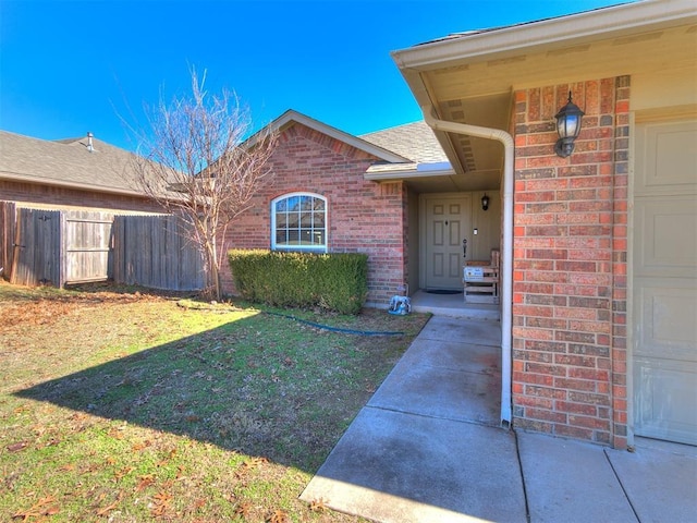 entrance to property featuring a lawn