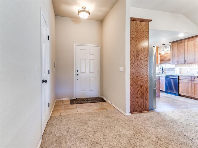 carpeted foyer with lofted ceiling