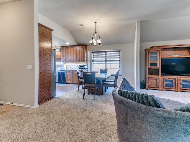 dining area with lofted ceiling, carpet, and a notable chandelier