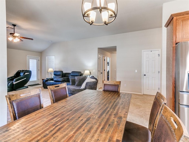 dining space featuring vaulted ceiling, ceiling fan with notable chandelier, and carpet floors