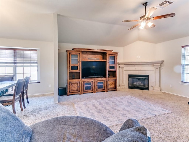 living room with vaulted ceiling, light colored carpet, ceiling fan, and a fireplace