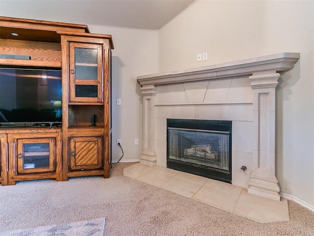 unfurnished living room with light colored carpet, a tile fireplace, and ornate columns