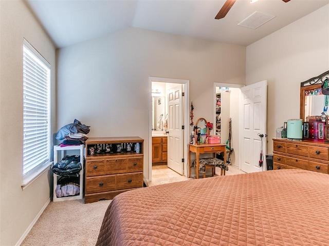 bedroom featuring ceiling fan, light colored carpet, connected bathroom, and vaulted ceiling