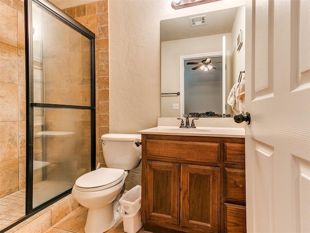 bathroom featuring vanity, a shower with door, and toilet