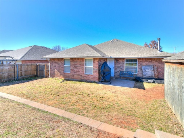 rear view of property featuring a patio area and a lawn