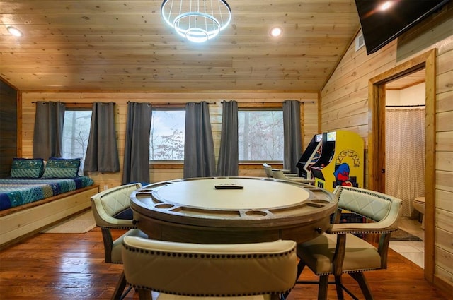 dining space featuring lofted ceiling, a wealth of natural light, dark hardwood / wood-style flooring, and wood walls