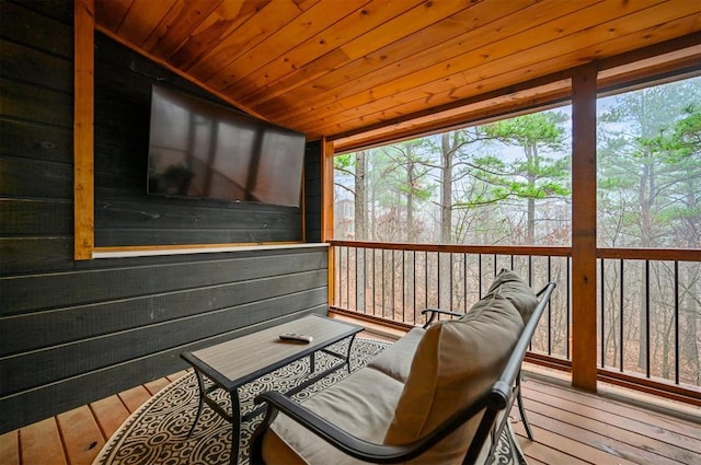 sunroom with lofted ceiling, a healthy amount of sunlight, and wood ceiling