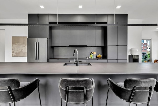 kitchen with freestanding refrigerator, a sink, gray cabinetry, and modern cabinets