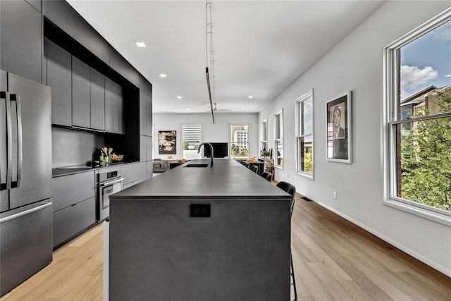 kitchen featuring dark countertops, appliances with stainless steel finishes, modern cabinets, and a sink