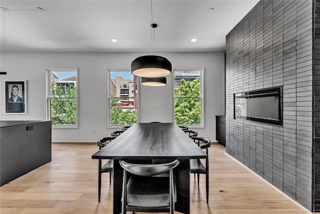 dining area with an accent wall and light wood finished floors