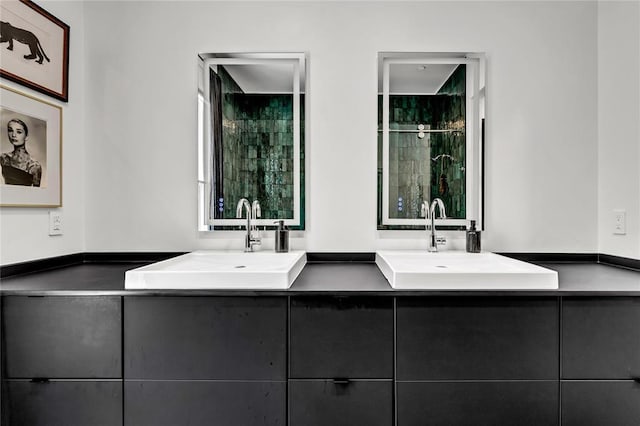 bathroom featuring a sink, a shower stall, and double vanity