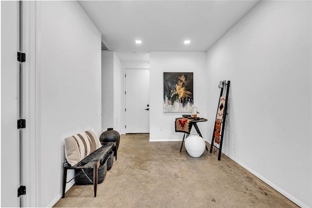 sitting room with visible vents, unfinished concrete floors, baseboards, and recessed lighting