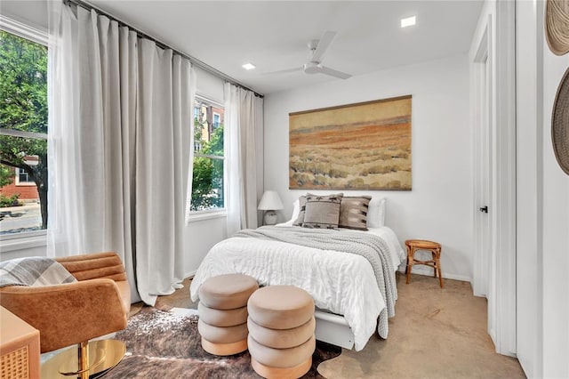 bedroom with light carpet, ceiling fan, and baseboards