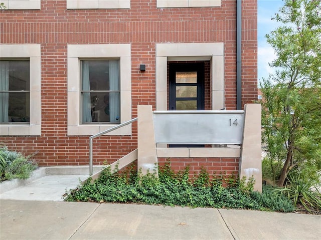 view of exterior entry with brick siding