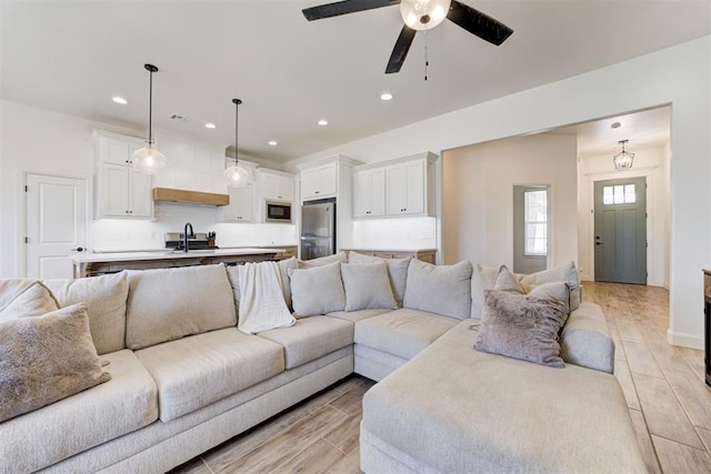 living room featuring ceiling fan and sink