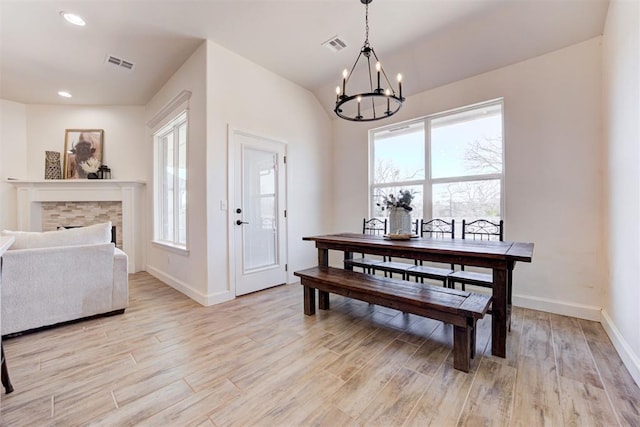 dining area featuring an inviting chandelier, plenty of natural light, and light wood-type flooring