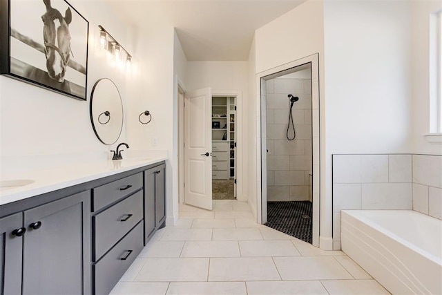 bathroom with tile patterned flooring, plus walk in shower, and vanity