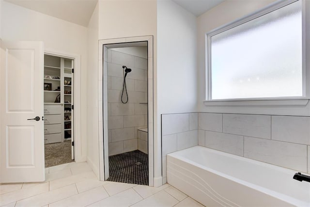 bathroom featuring tile patterned flooring and separate shower and tub