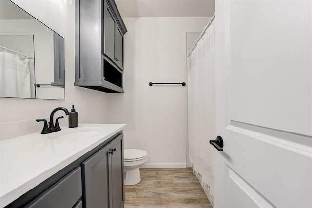 bathroom with vanity, wood-type flooring, and toilet