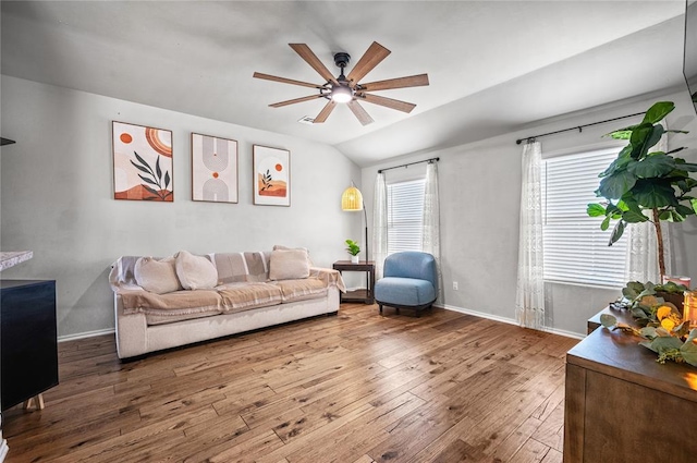 living room featuring wood-type flooring, ceiling fan, and vaulted ceiling