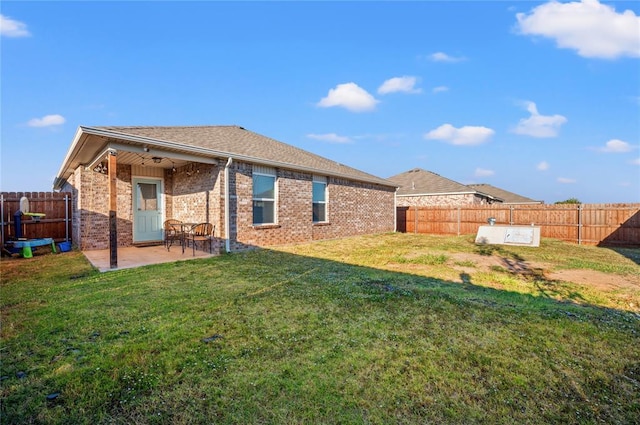 rear view of property featuring a patio and a yard