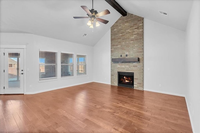 unfurnished living room with ceiling fan, a fireplace, wood-type flooring, and beam ceiling