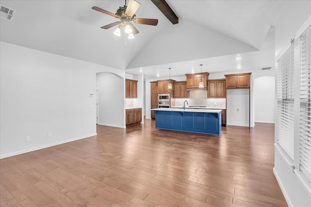 unfurnished living room with high vaulted ceiling, beamed ceiling, wood-type flooring, sink, and ceiling fan