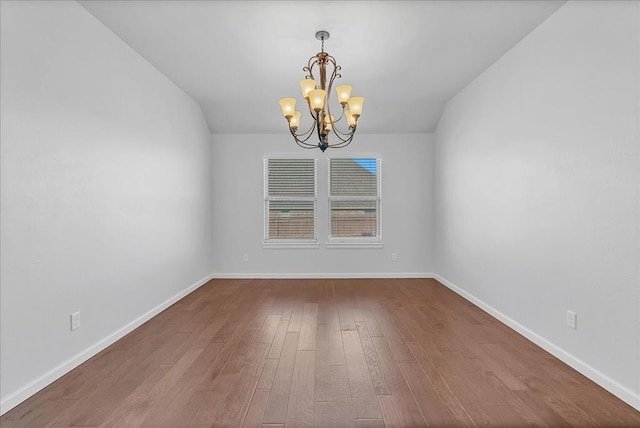 unfurnished room featuring hardwood / wood-style floors and a chandelier