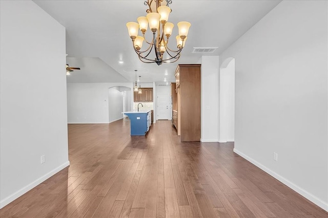 interior space featuring sink, ceiling fan with notable chandelier, and dark wood-type flooring