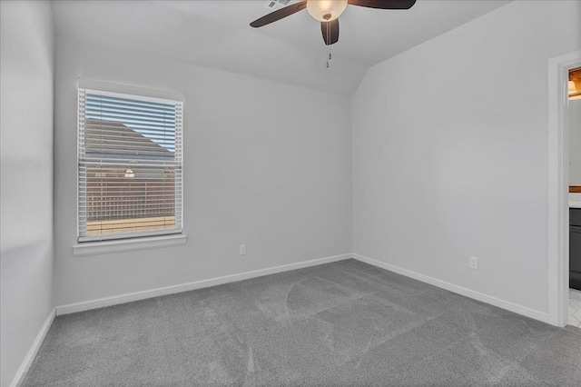 spare room featuring carpet floors, ceiling fan, and vaulted ceiling