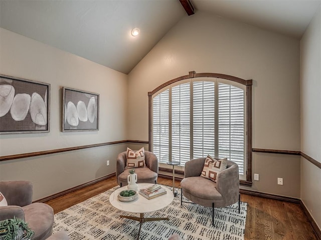 living area with hardwood / wood-style flooring, lofted ceiling with beams, and baseboard heating