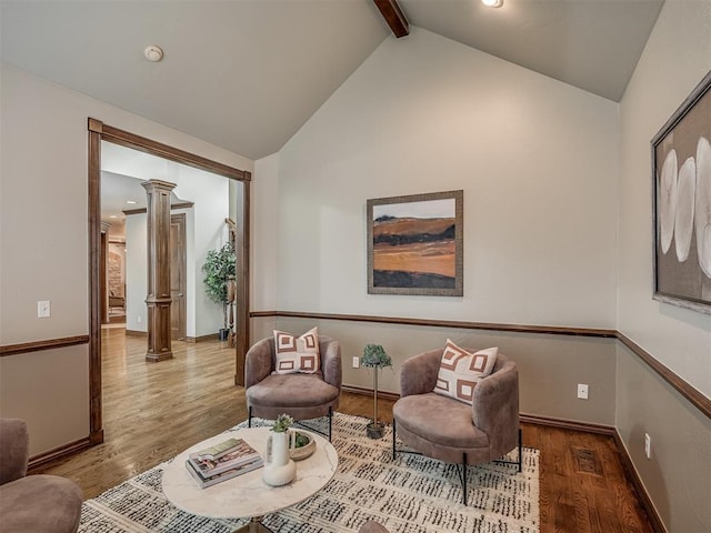 living area with decorative columns, hardwood / wood-style floors, high vaulted ceiling, and beamed ceiling