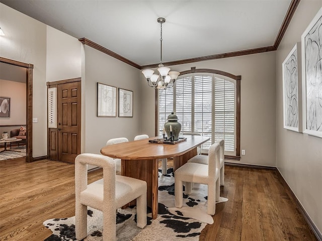 dining area featuring hardwood / wood-style flooring, ornamental molding, and a chandelier