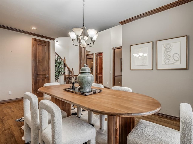 dining room featuring ornamental molding, hardwood / wood-style floors, and a notable chandelier