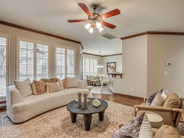 living room with ornamental molding, wood-type flooring, and ceiling fan