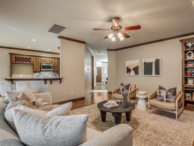 living room featuring crown molding, ceiling fan, and light hardwood / wood-style flooring