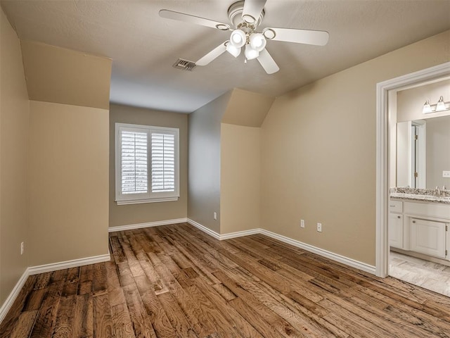 additional living space with sink, wood-type flooring, and ceiling fan