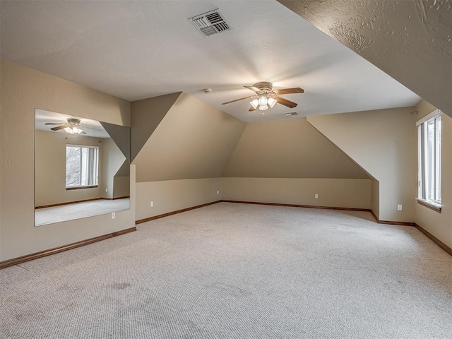 additional living space featuring light carpet, vaulted ceiling, and ceiling fan