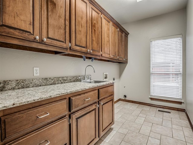 interior space featuring cabinets, hookup for an electric dryer, hookup for a washing machine, and sink