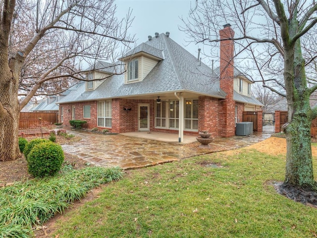 rear view of property with central AC unit, a yard, and a patio